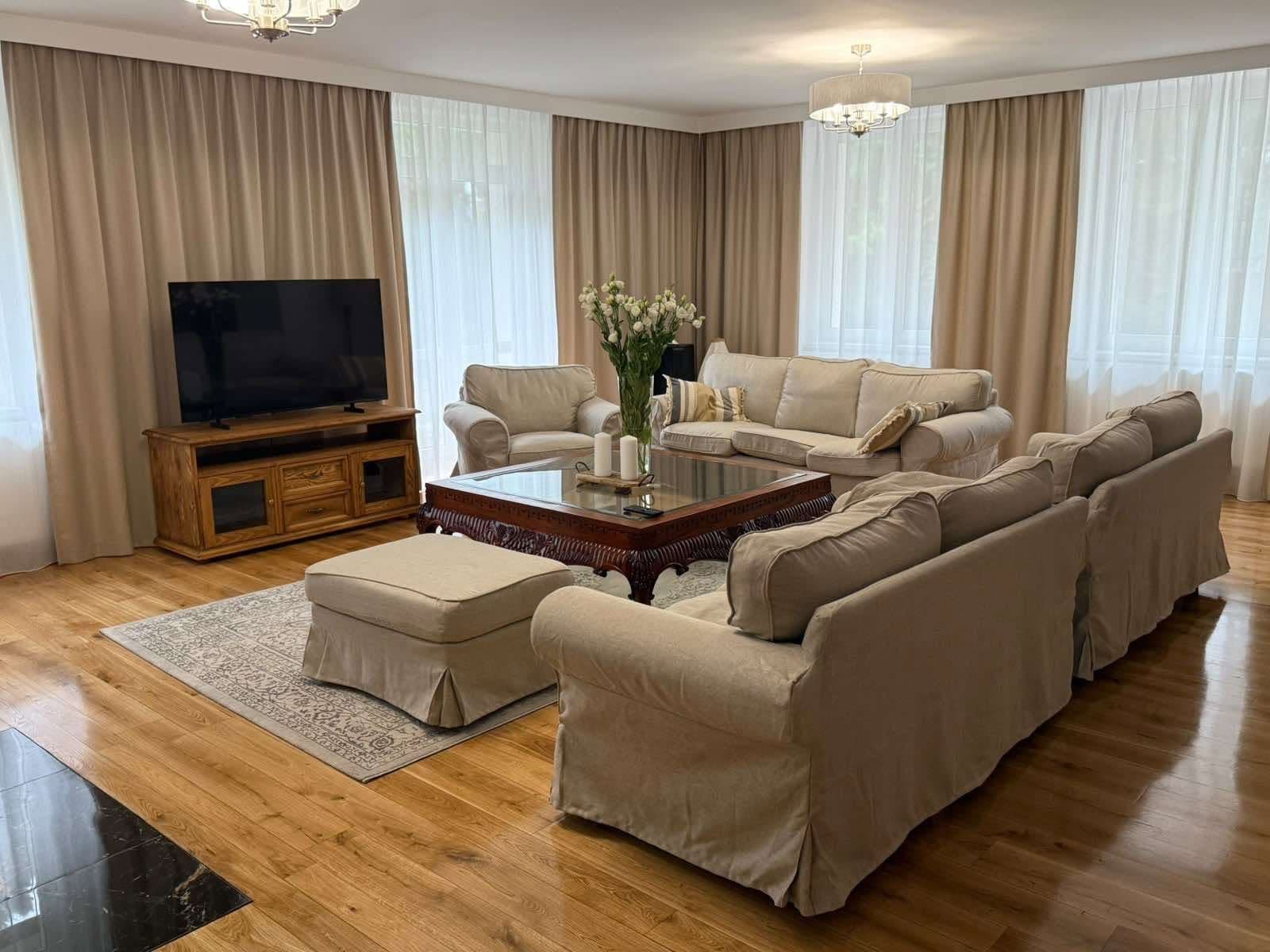 Beżowe zasłony i białe firany w przestronnym salonie